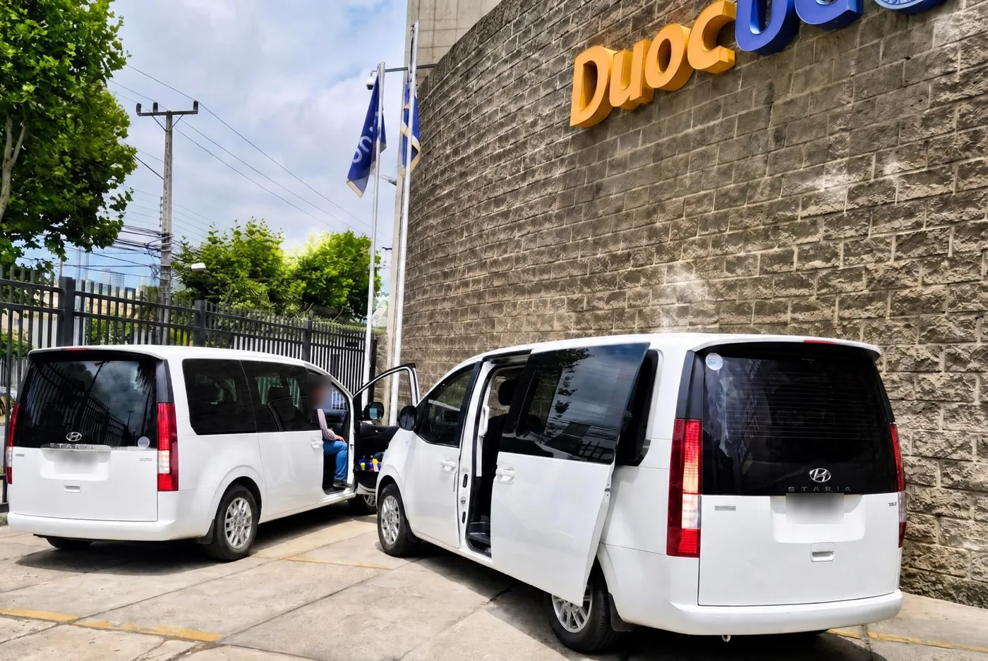 Vans de Travel Experts esperando a un grupo en la sede de Duoc UC